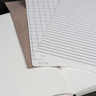 Sheet of graph paper with grid lines and ruled lines on a white surface.