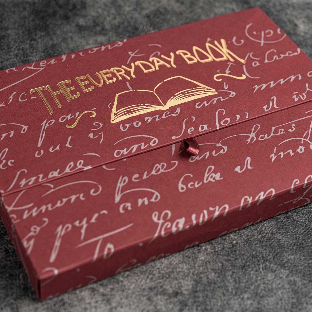 Red box with gold text and design on a gray surface