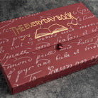 Red box with gold text and design on a gray surface