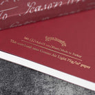 Red notebook with gold text on a textured surface