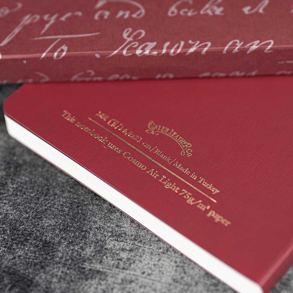 Red notebook with gold text on a textured surface