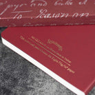 Red notebook with gold text on a textured surface