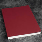 Red notebook on a textured gray surface