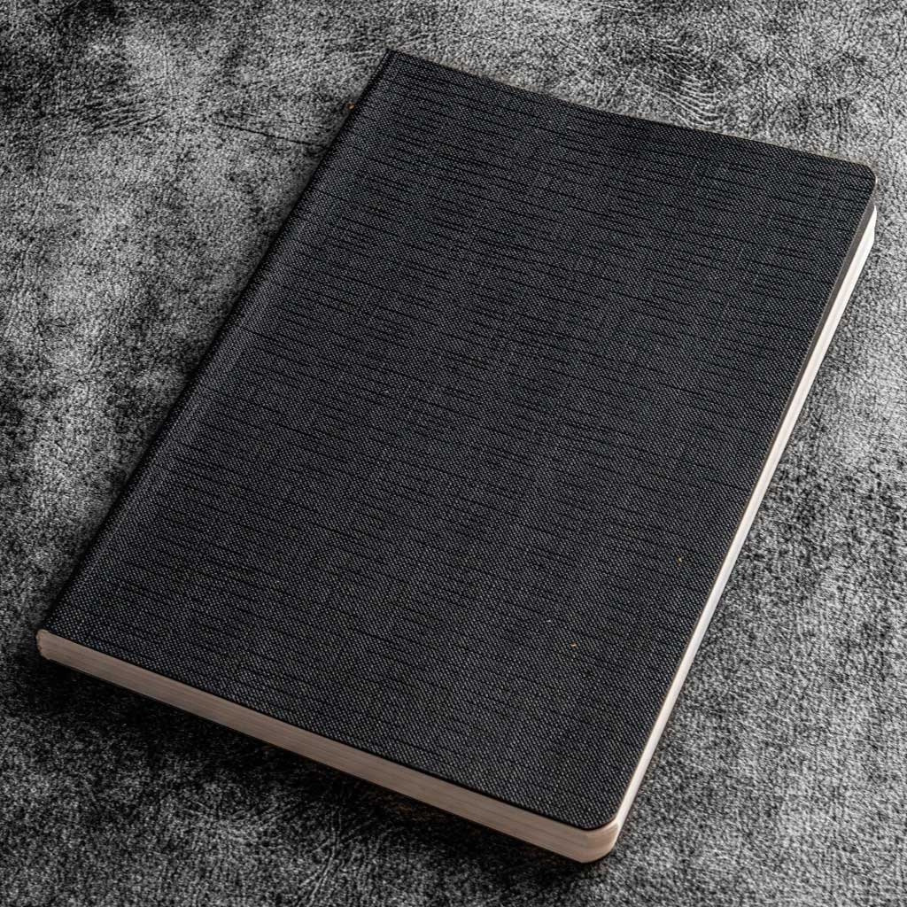 Black textured notebook on a gray textured surface