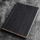 Black textured notebook on a gray textured surface