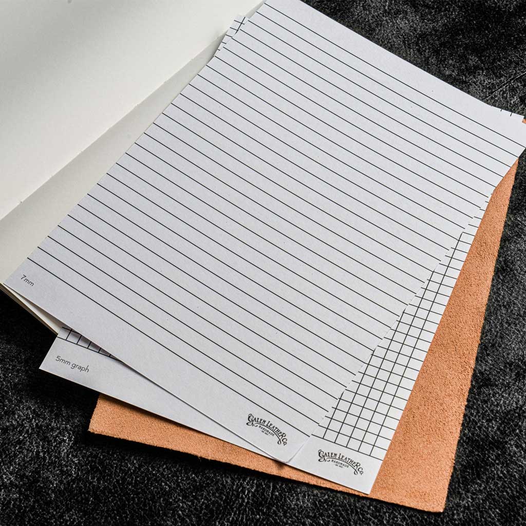 Sheet of lined and grid paper on a textured surface
