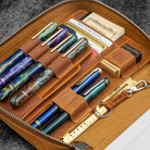 Brown leather case with pens, cards, and a ruler