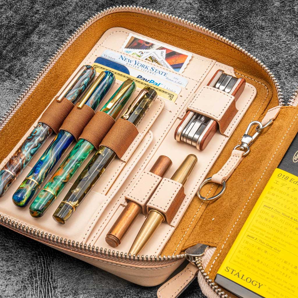 Set of fountain pens in a leather case on a textured surface