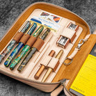 Set of fountain pens in a leather case on a textured surface