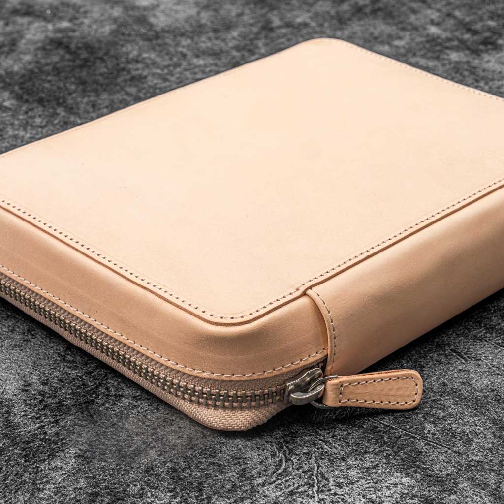 Natural undyed leather zippered case on a dark textured surface
