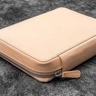 Natural undyed leather zippered case on a dark textured surface