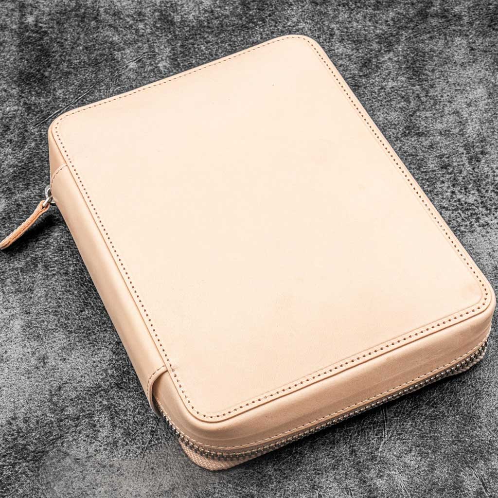Natural undyed leather zippered case on a dark textured surface