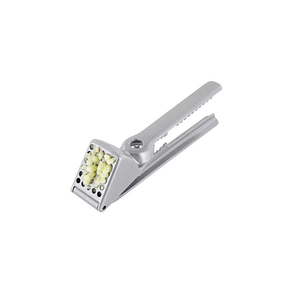 Silver garlic press with crushed garlic on a white background