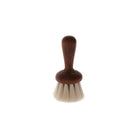 Small wooden face brush with light goat hair bristles on white background