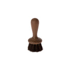Small wooden face brush with dark horsehair bristles on white background