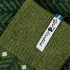 Green knitted fabric with a brand label on a textured background