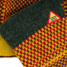 Knitted fabric with a triangular warning label on a patterned background