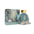 Ink bottle with gold cap and decorative packaging on a white background