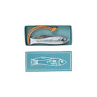A silver fish-shaped folding pocket knife with a brown leather loop, shown in an open teal box above its matching lid, which features a white fish outline and the words 'FISH KNIFE'.