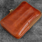Brown leather zippered pen case on gray background