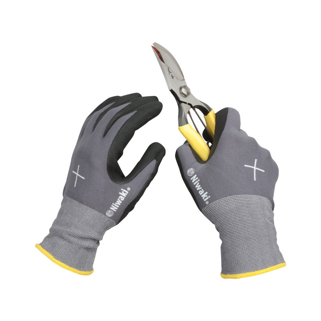 Gray gloves with yellow accents holding a pair of shears on a white background