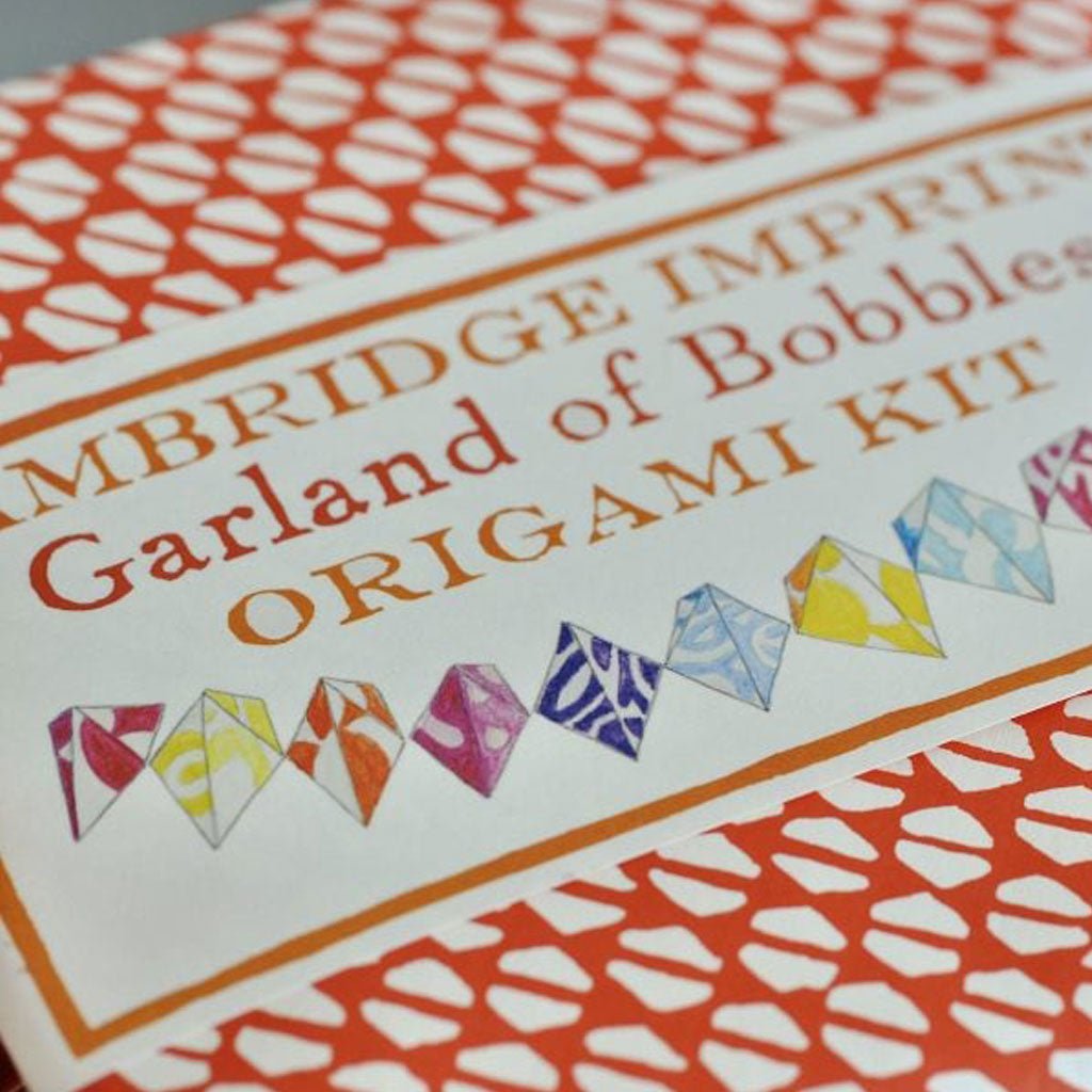 Origami kit packaging with colorful origami baubles and text on a white background