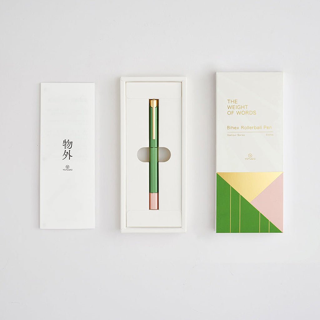 Green pen in white box and packaging on white surface