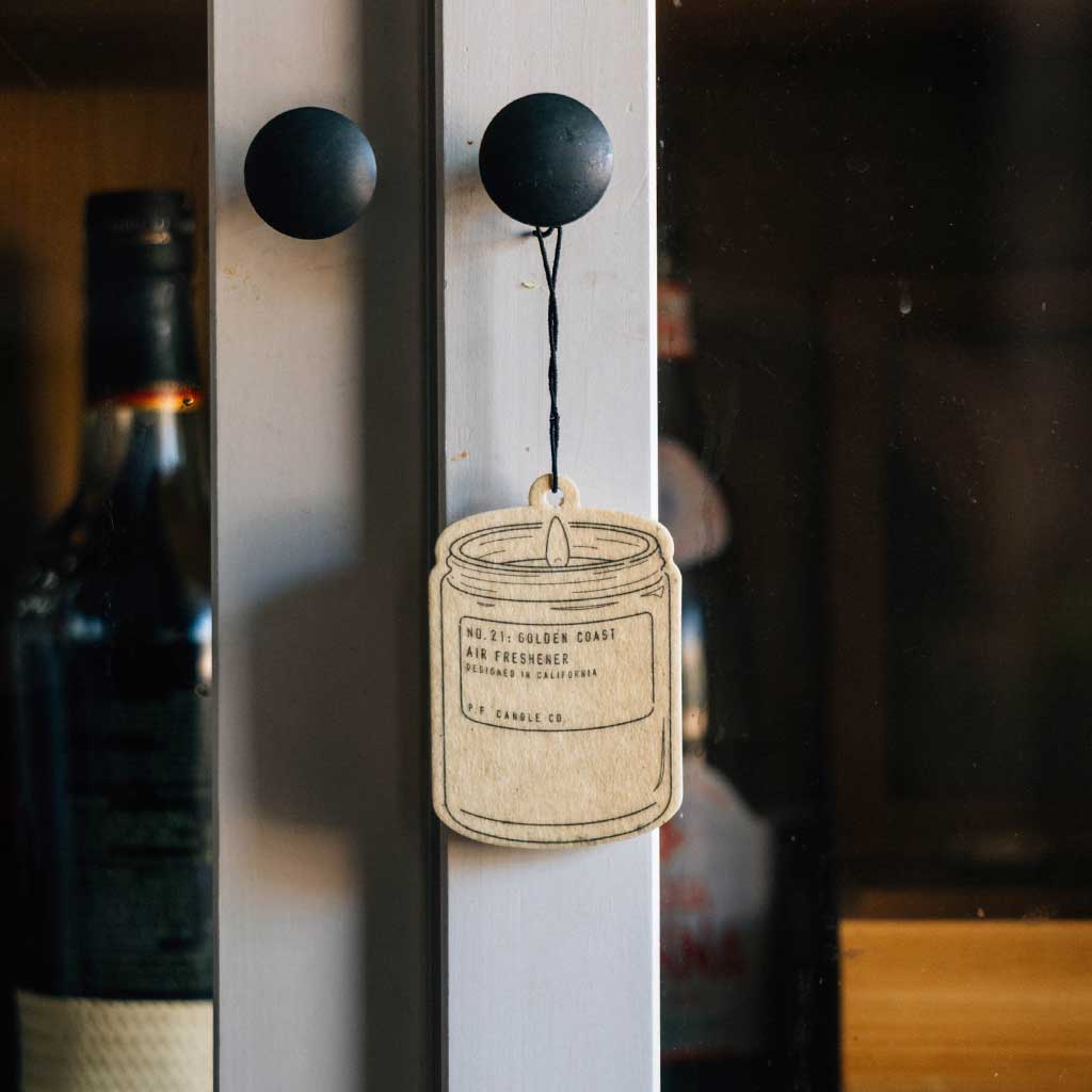 Golden coast air freshener hanging on cabinet door knob