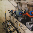 Textile spinning machine with a cone of blue yarn.