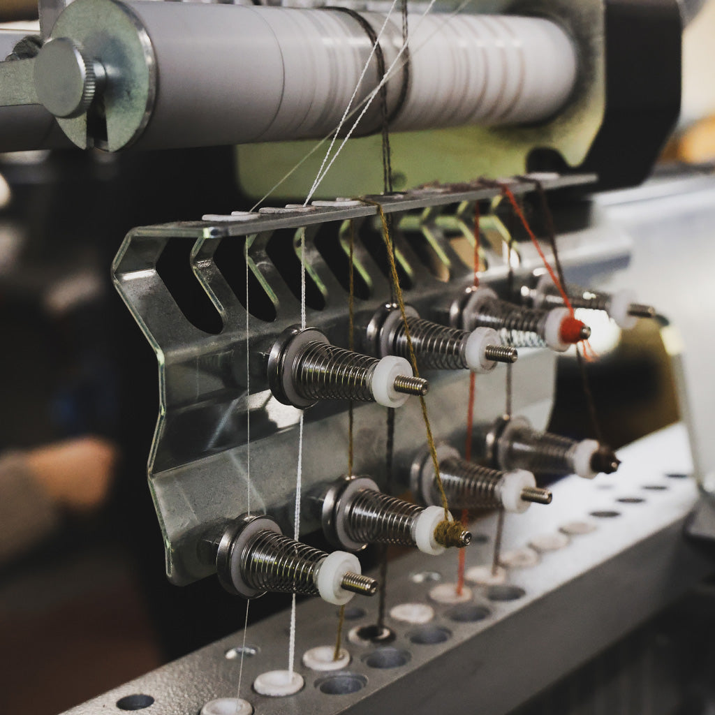 A knitting machine with various yarns.