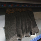 A knit sweater emerging from knitting machine.