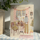 A holiday card on table with gingham tablecloth.