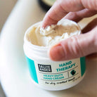 Hand dipping into SallyeAnder Heavy Duty Hand Therapy Cream for dry and cracked skin
