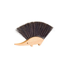 A hedgehog-shaped bristle brush with a light natural wood body and dark brown to black bristles, shown on a plain white background.