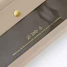 Light warm gray alettone case with front pocket and button closure for Hobonichi Techo Weeks on white background