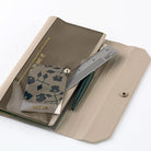 Light warm gray alettone case with front pocket with stationery accessories and button closure for Hobonichi Techo Weeks on white background