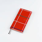 Clear Hobonichi Weeks clear cover with colorful dotted plaid pattern on red Weeks planner against white background