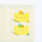 A close-up of a stationery page showing two yellow sticky note-style labels with printed text reading 'Masking tape stickers' and 'Film stickers,' decorated with overlapping colored geometric-shaped patterned stickers.