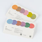 Two printed cards with circular color swatches and Japanese text, photographed on a clean white background.
