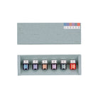 A set of six small glass ink bottles with silver caps arranged in a light gray presentation box, shown below the matching box lid. The bottles have color labels numbered 7 through 12.