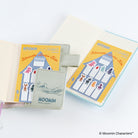 Moomin Silhouette Index Tab sets shown in two open notebooks. The set includes colorful character-shaped index tabs with a yellow and blue design, and a small matching tab cover featuring the Moomin logo.