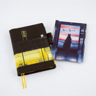 A5 Techo cover with airpot terminal design next to rectangular pencil board for A5 Techo of rabbit figure in front of airport window with colorful sunset on white background
