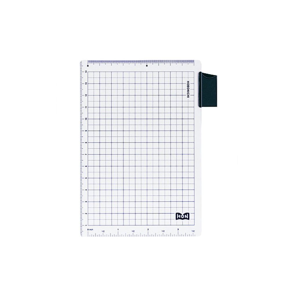 A clear A6-sized pencil board for Hobonichi Techo HON planners, with dark blue grid pattern, ruler measurements, and bookmark tab against white background