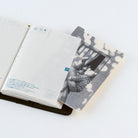 An open planner with blank grid pages on the left and a pencil board on the right, photographed on a clean white background.