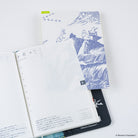 An open A6 Techo planner with gridded pages and an A6 Moomin pencil board under neath against a white background
