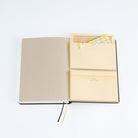 Two A6-sized pocket notebooks adhered to A5 Techo Cousin planner on white background