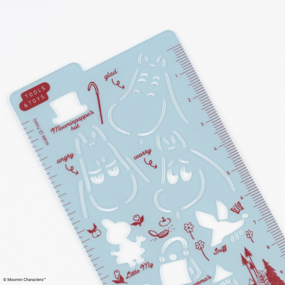 A light blue plastic craft stencil sheet featuring red and white line-art illustrations of Moomin characters and facial expressions, with measurement markings along the right edge.