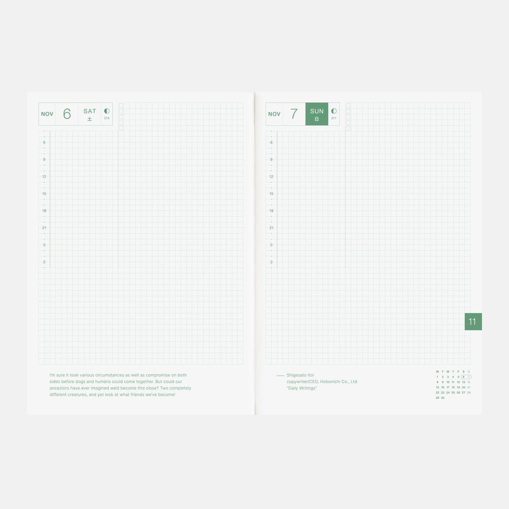 An open planner or notebook showing two white grid pages with a minimalist green and gray layout, photographed on a light gray background.