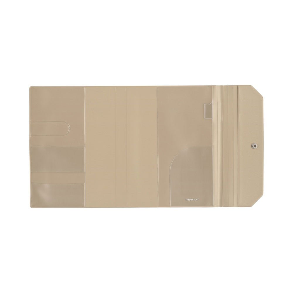 A flat view of the beige interior of a Hobonichi Techo Alettone planner cover with a tri-fold design on a white background. The interior features several clear pvc pockets and a pen loop. 