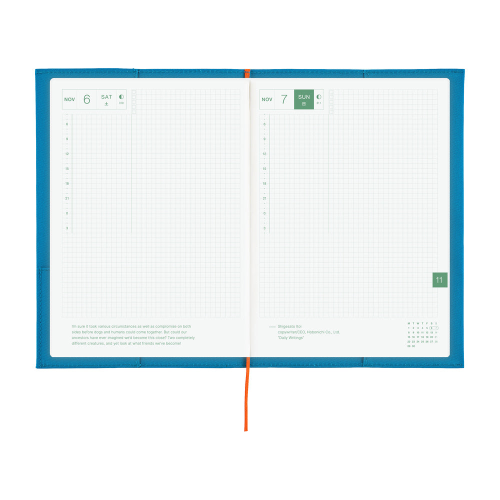 An open daily planner with a bright blue cover, white grid pages, and a red ribbon bookmark, photographed on a plain white background.